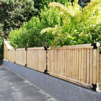 Naturfarbener Bambuszaun mit robusten Bambusstäben, der als dekorativer Sichtschutz dient und durch die dichte Anordnung der Stäbe Privatsphäre bietet.