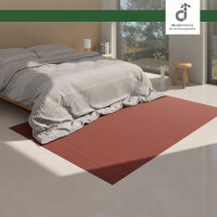 Moderner Wohnbereich mit einem roten Bambusteppich MASSIVE aurora auf hellen Holzdielen. Der Teppich mit 17mm Stegen bringt einen warmen, natürlichen Akzent in den Raum.