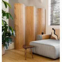 Eleganter doppelseitiger Paravent aus Bambus in hellem Naturton, der einen modernen Raumteiler in einem minimalistischen Wohnbereich mit grauem Sofa und Grünpflanze zeigt.