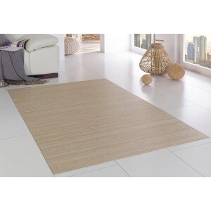 Kind sitzt auf einem Bambusteppich in einem hellen Wohnzimmer und spielt mit Bildern. Der rote Teppich hat dicke, parallele Stege und misst etwa 40x60 cm.