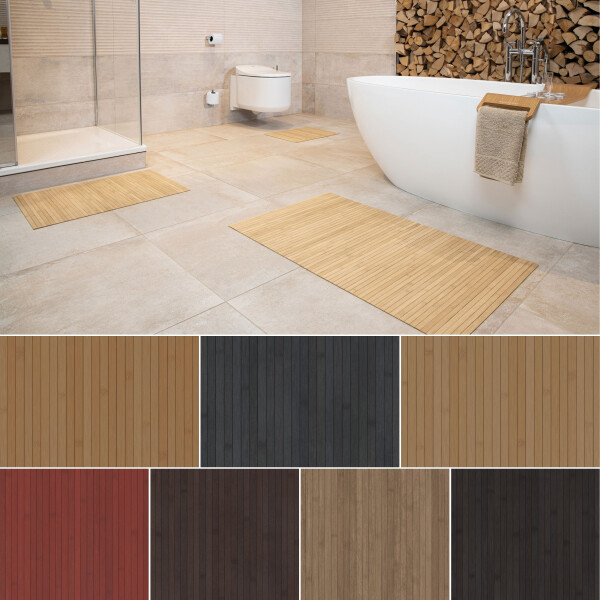 Drei Bambus-Badteppiche in verschiedenen Größen, platziert in einem modernen Badezimmer mit freistehender Badewanne und Holzwand. Die Teppiche haben ein elegantes, gestreiftes Design und sind in natürlicher Bambusfarbe gehalten.