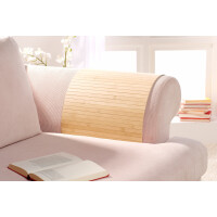 Elegante Bambus-Couchablage PURE in hellbrauner Farbe, platziert auf einem hellen Sofa mit einem aufgeschlagenen Buch in der Nähe.