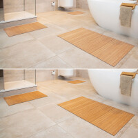Drei Bambus Badematten in verschiedenen Größen, die vor einer Badewanne und einer Dusche auf einem gefliesten Badezimmerboden platziert sind. Die Matten bestehen aus hellbraunem Bambus mit klaren, parallelen Lamellen und bieten eine natürliche, stilvolle Optik.