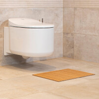Bambus Badematte GRAND nature in natürlichem Holzdesign, platziert vor einer modernen, wandhängenden Toilette. Die quadratische Matte misst 40 x 50 cm und fügt sich harmonisch in ein elegantes Badezimmerambiente ein.