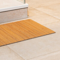 Ein Bambus-Badteppich in Naturfarbe, der vor einer Badewanne auf einem hellen, gefliesten Boden liegt. Die Badematte hat eine Größe von 40 x 50 cm und besteht aus horizontal angeordneten Bambuslamellen, die ein modernes und natürliches Design bieten.
