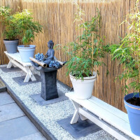 Stilvoller Garten mit Bambus-Sichtschutz aus Rollzaun CALAMA in 100 cm x 500 cm, der eine natürliche, ruhige Atmosphäre schafft.