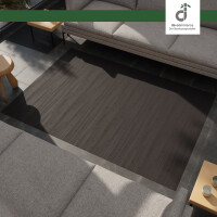 Dunkelbrauner Bambusteppich mit horizontalen Maserungen, der von einer Hand mit einem feuchten Tuch gereinigt wird. Im Hintergrund eine helle, moderne Wohnküche mit Holzmöbeln.