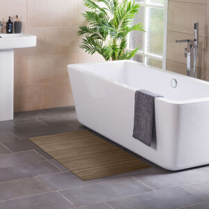 Badezimmer mit modernem Design, in dem ein rechteckiger Bambus-Badteppich in Taupe vor einer weißen Badewanne liegt, neben einem Waschbecken und einer Zimmerpflanze.