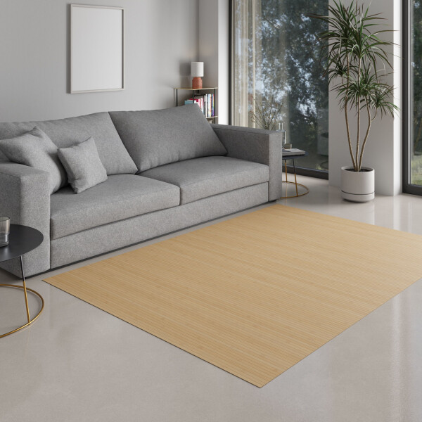 Mädchen sitzt auf einem großen Bambusteppich mit natürlichem Streifenmuster in einem hellen Wohnzimmer und malt. Der Teppich hat eine breite, einheitliche Fläche und passt harmonisch in den modernen Raum.