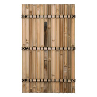 Sichtschutz aus Bambus mit hohen, vertikal angeordneten Stäben, befestigt mit horizontalen Drahtreihen. Die Bambusstäbe sind natürlich hellbraun gefärbt und bieten eine dekorative, asiatisch inspirierte Abgrenzung. Der Zaun ist in einer gemütlichen Ecke mit Kiesboden und meditativer Dekoration platziert.