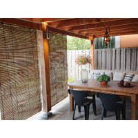 Bambusrollo als Sonnenschutz und Sichtschutz an einer Holzüberdachung, teilweise heruntergelassen, bietet Privatsphäre und Schatten in einem modernen Außenbereich mit Esstisch und Stühlen.