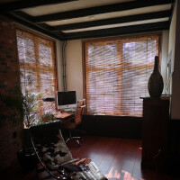 Bambus Sonnenschutz Jalousie mit natürlichem Design, die an einem Fenster in einem modernen Arbeitszimmer angebracht ist. Die Jalousie bietet Sichtschutz und filtert das Tageslicht sanft. Die Maße der Jalousie betragen 150x200 cm, was ideal für größere Fenster ist.