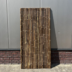 Hochwertige Bambus-Sichtschutzmatte in dunkler, naturähnlicher Färbung, bestehend aus dicht aneinandergereihten Bambusstäben. Die Matte bietet eine Höhe von 180 cm und eine Breite von 90 cm, ideal für Gartenzäune oder als dekorativer Sichtschutz. Die Stäbe sind gleichmäßig geschnitten und verleihen dem Garten eine natürliche, asiatisch inspirierte Ästhetik.