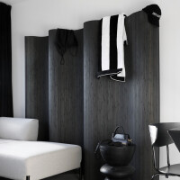 Doppelseitiger Paravent aus dunklem Bambus mit wellenförmigem Design, der eine moderne und elegante Raumtrennung bietet.