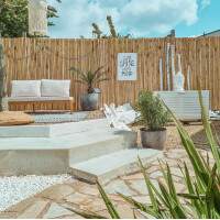 Sichtschutz aus Bambus mit natürlichem Design, der eine gemütliche Sitzecke im Garten abgrenzt. Der Rollzaun ATY NATURE bietet Privatsphäre und verleiht dem Außenbereich eine warme, einladende Atmosphäre.