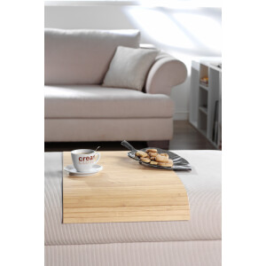 Elegante Couchablage aus Bambus in natürlicher Holzoptik, die auf einem Sofa platziert ist. Auf der Ablage stehen ein Kaffeebecher und ein Teller mit Keksen. Die Ablage bietet eine stilvolle und praktische Lösung, um Gegenstände griffbereit zu halten, während sie gleichzeitig die Ästhetik des Raumes unterstreicht.