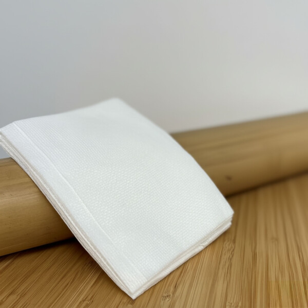 5 Pflegetücher liegen vor einen Bambuspfosten. Vor dem Bambuspfosten steht das Bamboo Care Öl von der Marke DE-Commerce, beide Produkte ergänzen sich ideal für die Bambuspflege, oben ist das DE-Commerce Logo.