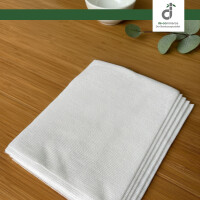 Vor einem Bambus Hintergrund liegen die 5 Pflegetücher. Zudem befindet sich im Hintergrund eine beige Vase mit getrocknetem Pampasgras, sowie dünne Bambusrohre.