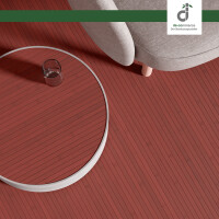 Moderne Wohnzimmereinrichtung mit rotem Bambusparkett FLEXBAMBOO aurora, das eine nat�rliche, warme Atmosph�re schafft. Der Boden besteht aus gleichm��igen, feinen Streifen, die eine einheitliche Optik bieten. Ein runder Tisch mit Metallrahmen und ein bequemer Sessel erg�nzen die stilvolle Einrichtung.