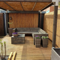 Sichtschutz aus Bambus von CALAMA, 120 cm x 300 cm, in einem Outdoor-Bereich mit Holzpergola und Sitzecke. Der Bambuszaun bietet Privatsphäre und natürliches Ambiente.