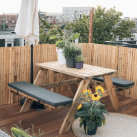 Bambus-Sichtschutz aus natürlichen Rollzäunen, 100 cm x 180 cm, eingerahmt von einem Holzpicnic-Tisch auf einer Terrasse mit Pflanzen.