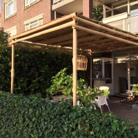 Bambus Pergola NATURE mit einer Größe von 400x300x300 cm, die als schattenspendende Struktur in einem Garten dient. Die Pergola besteht aus robustem Bambus und bietet eine natürliche, ästhetische Ergänzung für jeden Außenbereich. Sie ist ideal für entspannte Stunden im Freien und schafft eine gemütliche Atmosphäre.