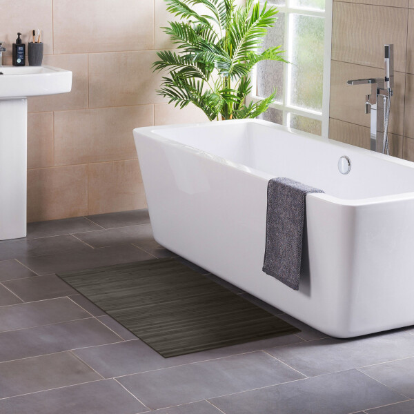 Moderner Badteppich mit Streifenmuster in dunkelgrau, platziert vor einer freistehenden Badewanne. Der Teppich ist aus strapazierfähigem und pflegeleichtem Material gefertigt und verleiht dem Badezimmer eine elegante Note. Maße: 60 x 100 cm.