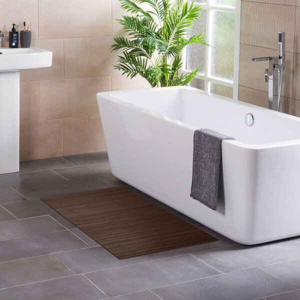 Bambus Badteppich LINES Mocha in der Größe 40 x 50 cm, der vor einer modernen Badewanne platziert ist. Der Teppich zeigt ein elegantes, gestreiftes Design in warmen Mocha-Tönen und passt ideal in ein stilvolles Badezimmer.
