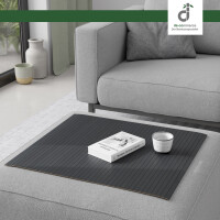 Flexible Couchablage aus Bambus mit Stegstruktur in bläulichem Grau liegt auf einer grauen Couch und dient als stabile Ablagefläche für Buch und Kerze – ideal als Sofa-Tablett oder Schutz für Polster, oben rechts DE-COmmerce Logo.