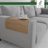 Flexible, hellbraune Couchablage aus Bambus auf einer eckigen Armlehne eines grauen Sofas mit einer Kaffeetasse darauf, oben rechts ist das DE-COmmerce Logo.