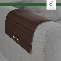Flexible Couchablage aus Bambus in mittelbraun mit Kaffeeton mit schmalen Bambusstegen, passend über eine graue runde Sofa-Armlehne gelegt und ideal als praktische Ablagefläche für Getränke, Snacks oder Fernbedienung.