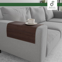 Flexible, mittelbraune Couchablage aus Bambus auf einer eckigen Armlehne eines grauen Sofas mit einer Kaffeetasse darauf, oben rechts ist das DE-COmmerce Logo.