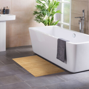 Eleganter Bambus-Badteppich in Naturfarbe, platziert vor einer modernen weißen Badewanne. Der Teppich zeigt dezente Linienmuster und sorgt für ein natürliches, stilvolles Ambiente im Badezimmer.