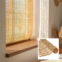 Sonnendurchflutetes Fenster mit heller, heruntergelassener Schilfjalousie. Auf der hölzernen Fensterbank fällt warmes, gefiltertes Licht ein, daneben steht eine Vase mit getrocknetem Pampasgras in einem gemütlichen Raum.