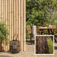 Ein Sichtschutz aus Bambus in XXL-Größe mit natürlicher Optik, der eine gemütliche Sitzecke im Garten abgrenzt und Privatsphäre bietet. Im Hintergrund sorgt die Bambuswand für eine harmonische, ruhige Atmosphäre.