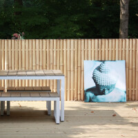 Ein Sichtschutz aus Bambus in XXL-Größe mit natürlicher Optik, der eine gemütliche Sitzecke im Garten abgrenzt und Privatsphäre bietet. Im Hintergrund sorgt die Bambuswand für eine harmonische, ruhige Atmosphäre.