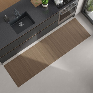 Moderne Küchenansicht von oben mit dunkler Arbeitsplatte, eingebautem schwarzen Spülbecken und Herd; auf dem hellen Boden liegt ein langer, rechteckiger, hellgrau-brauner Bambus-Küchenläufer.