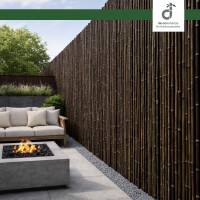 Moderner Garten mit dunklen Bambus-Windschutz an Metallpfosten, Holzsteg und Rasenfläche, im Hintergrund eine hohe grüne Hecke unter blauem Himmel, oben rechts das DE-COmmerce Logo.