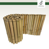 Geschwungene Bambus-Beeteinfassung trennt ein blühendes Lavendelbeet von einer gepflegten Rasenfläche. Auf dem Rasen liegen Gartenhandschuhe und eine Gartenschaufel, oben rechts das DE-COmmerce Logo.