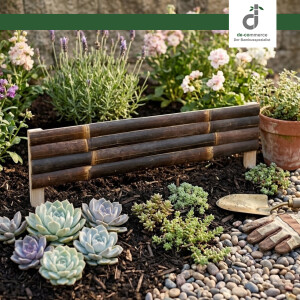 Beetumrandung aus dunklem Bambus im Garten, umgeben von blühenden Pflanzen, Lavendel und Sukkulenten; daneben liegen Gartenhandschuhe und eine kleine Schaufel auf Kies.