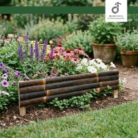 Blumenbeet im Garten mit violetten, rosa und weißen Blüten, eingefasst von einer niedrigen Umrandung aus dunklen Bambusstäben; im Hintergrund stehen Blumentöpfe mit grünen Pflanzen; oben rechts das DE-COmmerce Logo.