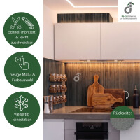 Bambus-Wandbelag in stahlgrau als stilvolle Wandgestaltung in einer modernen weißen Küche. Die natürliche Bambusstruktur schafft eine warme und wohnliche Atmosphäre. Das Produktbild zeigt zudem die schnelle und einfache Montage, leichte Zuschneidbarkeit, große Maß- und Farbauswahl, vielseitigen Einsatzmöglichkeiten sowie die rutschfeste Rückseite des Wandbelags „Vlies mit Dots“; oben rechts das DE-COmmerce Logo.