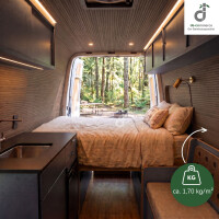Gemütlicher Campervan mit hellgrau-braunem Bambus-Wand- und Deckenbelag, Doppelbett und kompakter Küche; durch die geöffneten Hecktüren fällt der Blick in einen grünen Wald. Eine Grafik weist auf das geringe Gewicht des Wandbelags von ca. 1,70 kg/m² hin, oben rechts das DE-COmmerce Logo.