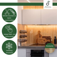 Bambus-Wandbelag in warmer Naturoptik als stilvolle Wandgestaltung in einer modernen weißen Küche. Die natürliche Bambusstruktur schafft eine warme und wohnliche Atmosphäre. Das Produktbild zeigt zudem die schnelle und einfache Montage, leichte Zuschneidbarkeit, große Maß- und Farbauswahl, vielseitigen Einsatzmöglichkeiten sowie die strukturierte Rückseite des Wandbelags „Gaze“; oben rechts das DE-COmmerce Logo.
