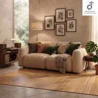 Natürlicher Bambusteppich mit 50 mm breiten Bambuslamellen unter einem beigen Sofa in einem gemütlichen Wohnzimmer mit grünen Dekokissen, Holzmöbeln und stilvoller Pflanzendekoration; oben rechts das DE-COmmerce logo.